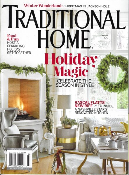 A cozy, festive living room decorated for Christmas with greenery, a fireplace, and holiday accents.