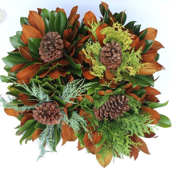 Bright autumn wreath with pinecones, magnolia leaves, and greenery for seasonal decor.