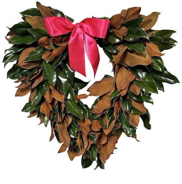 Bright holiday wreath with green and brown leaves, adorned with a pink ribbon bow, perfect for festi.