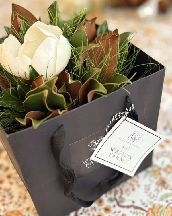 Elegant white magnolia flower arrangement in a Weston Farms gift bag, perfect for special occasions.