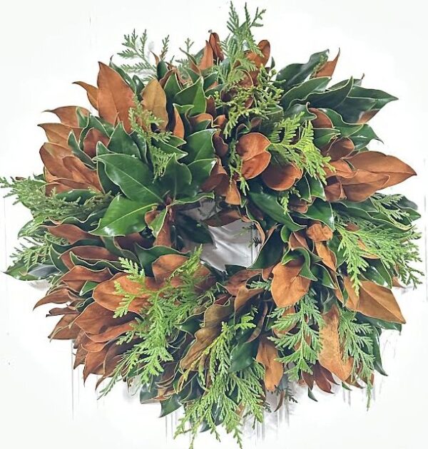 Lush holiday greenery wreath with magnolia leaves and ferns for festive decoration.