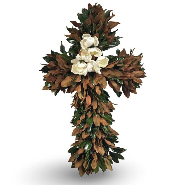 Easter cross decorated with magnolia flowers and brown leaves, symbolizing spring and renewal.