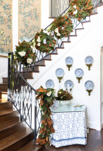 Elegant staircase decorated with lush floral garland and white roses, showcasing classic interior de.