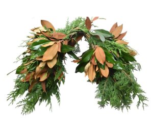 Festive greenery wreath with magnolia and cedar leaves for holiday decor.