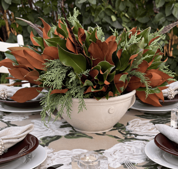 Elegant table centerpiece with lush greenery and brown leaves for Weston Farms event.